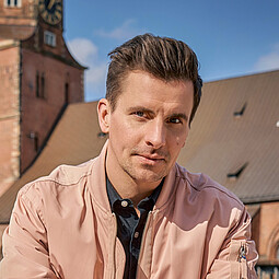 Julian Sengelmann mit Kirchturm im Hintergrund